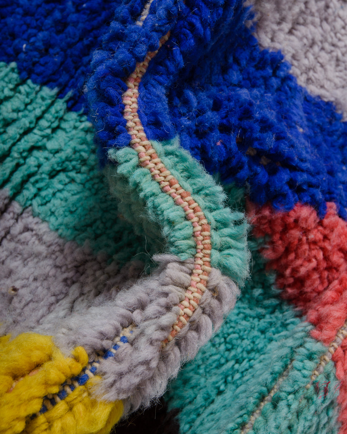 Detail of wool berber rug showing depth of pile and different coloured wool used.